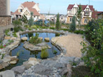 Изюминкой декоративного пруда является небольшой зеленый островок и дорожка из каменных плит, позволяющая пройти над поверхностью воды, сократив путь из дома до пляжа